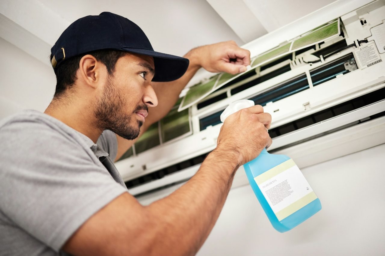 air conditioner cleaning and man with electrical machine check in a home with ac repair maintenan